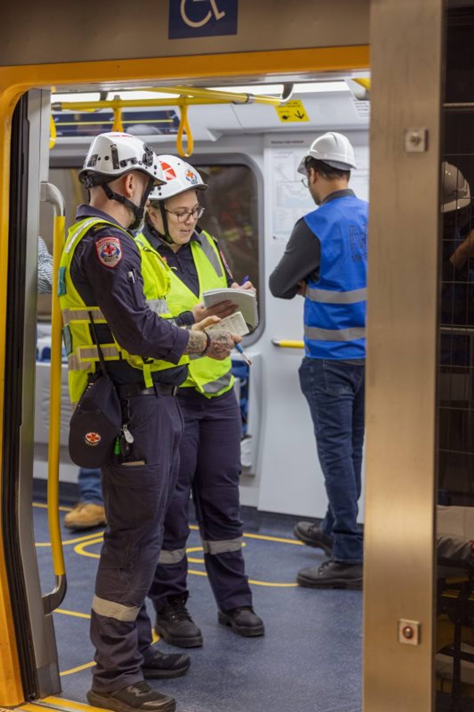 Photo shows two paramedics standing on a train during a training exercise