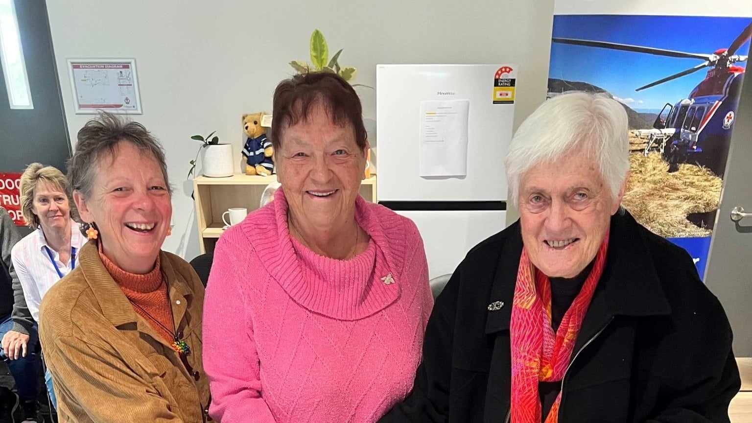 Three smiling ladies looking at the camera.