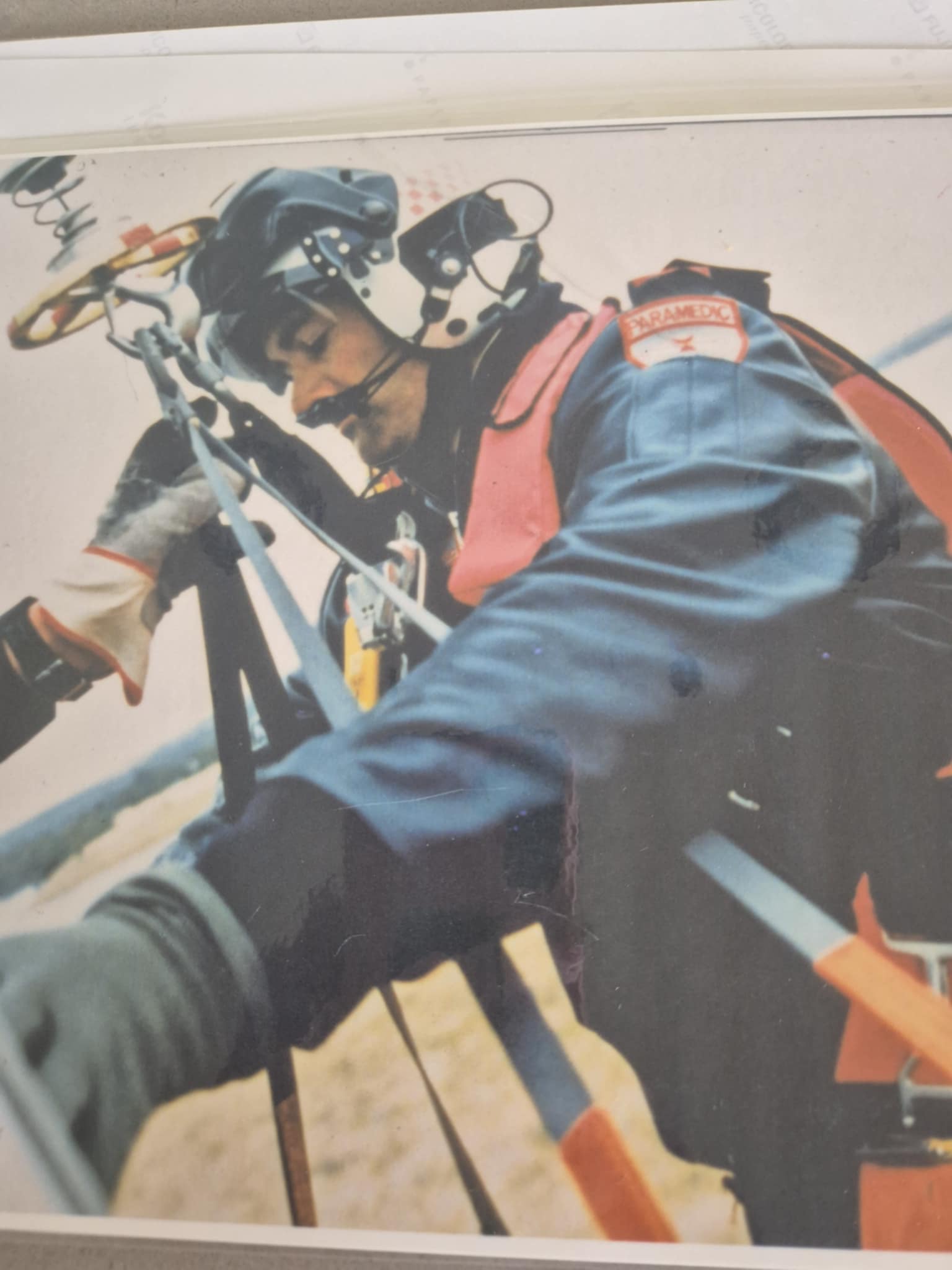 A paramedic wearing a helmet and strapped into a harness.