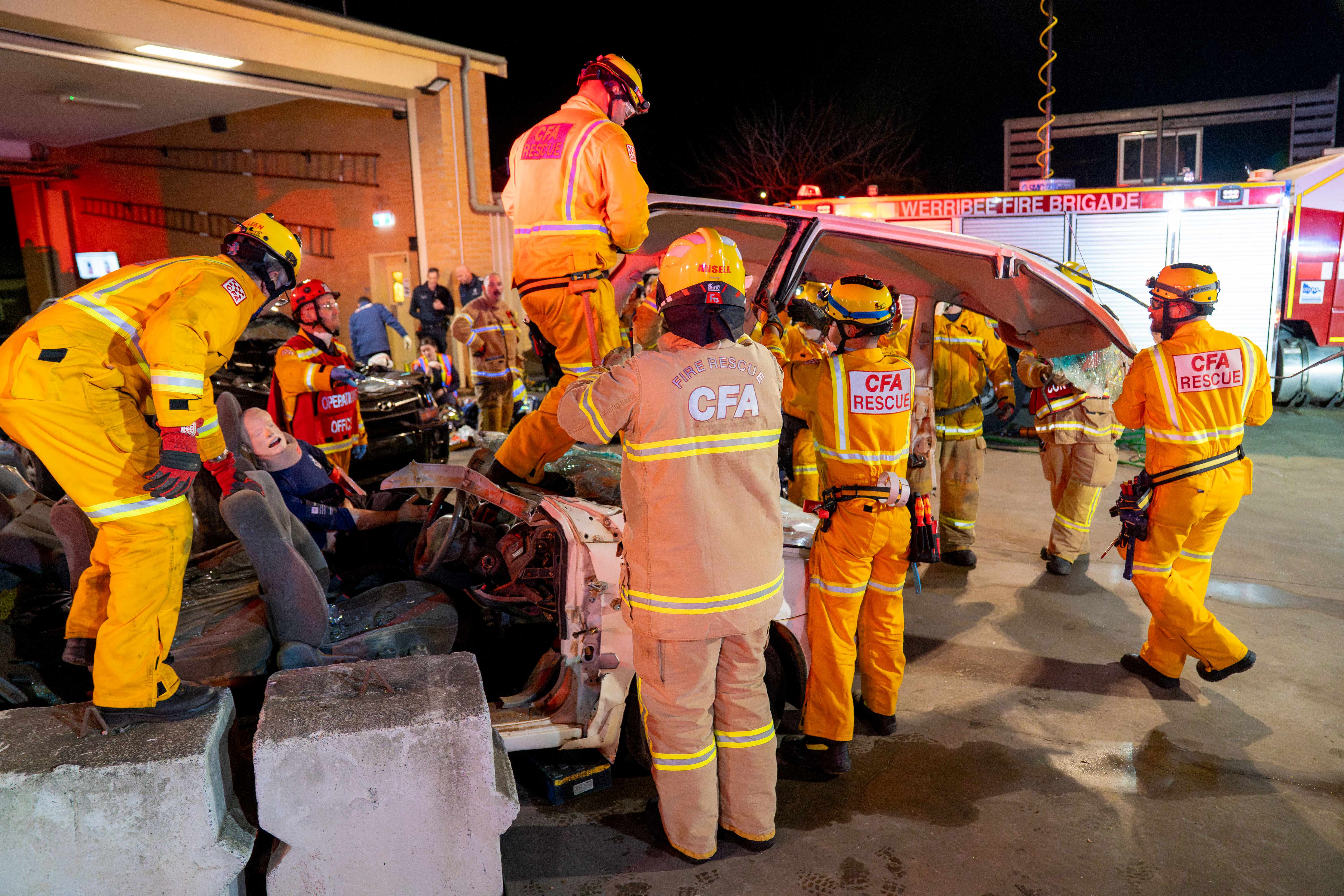CFA members lift the roof of a car which has been cut off. A mannequin is inside what remains of the vehicle.
