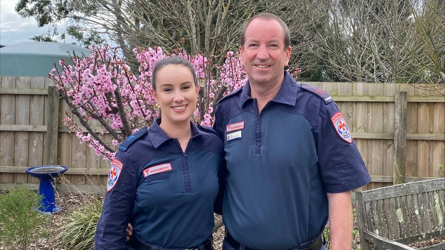 A woman and man standing next to each other. Both are wearing paramedic uniforms.