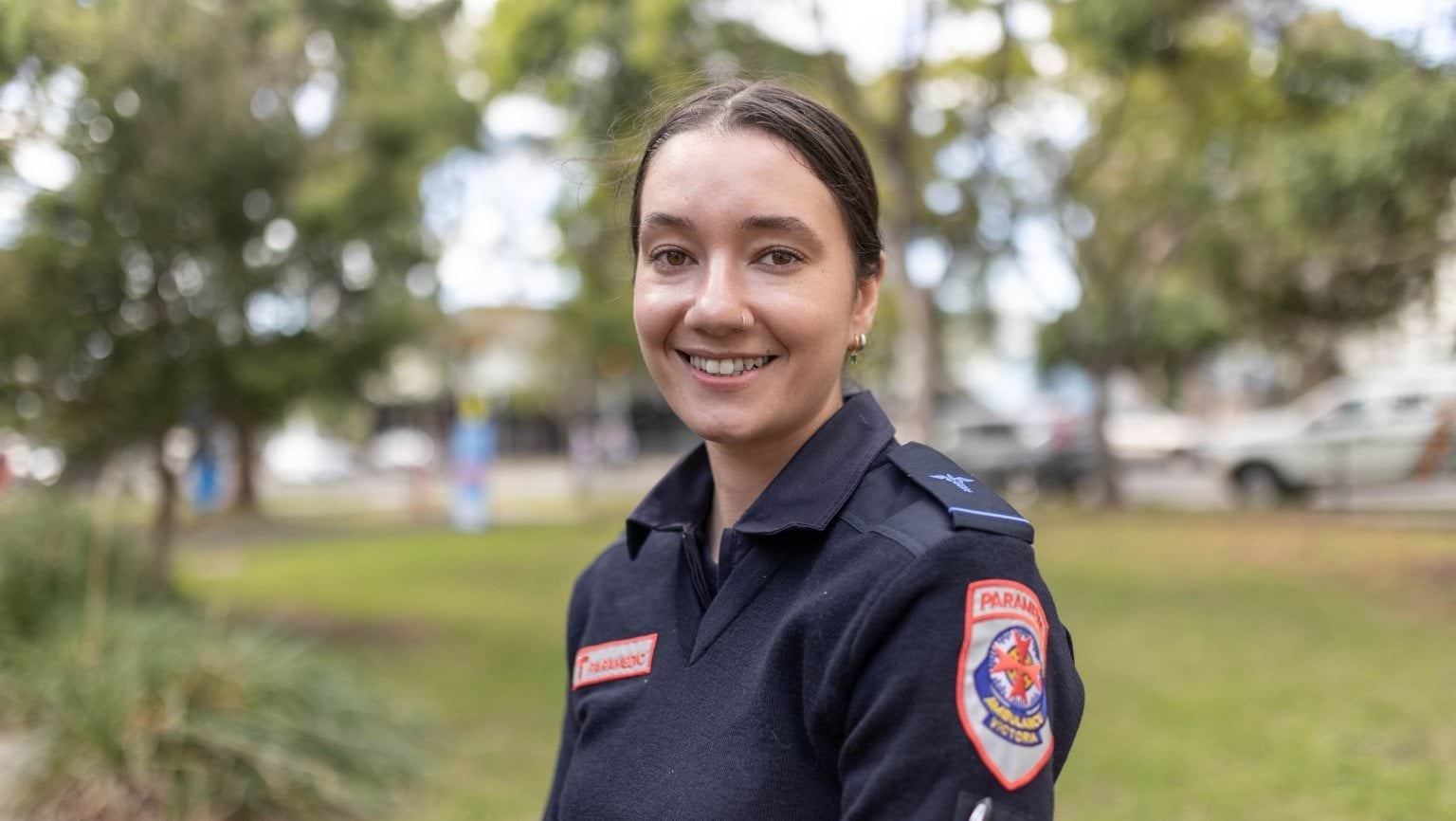 A headshot of a woman in Ambulance Victoria uniform smiling for the camera.