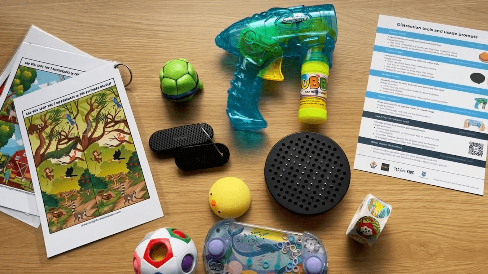 A selection of small toys and handouts spread across a wooden table top.