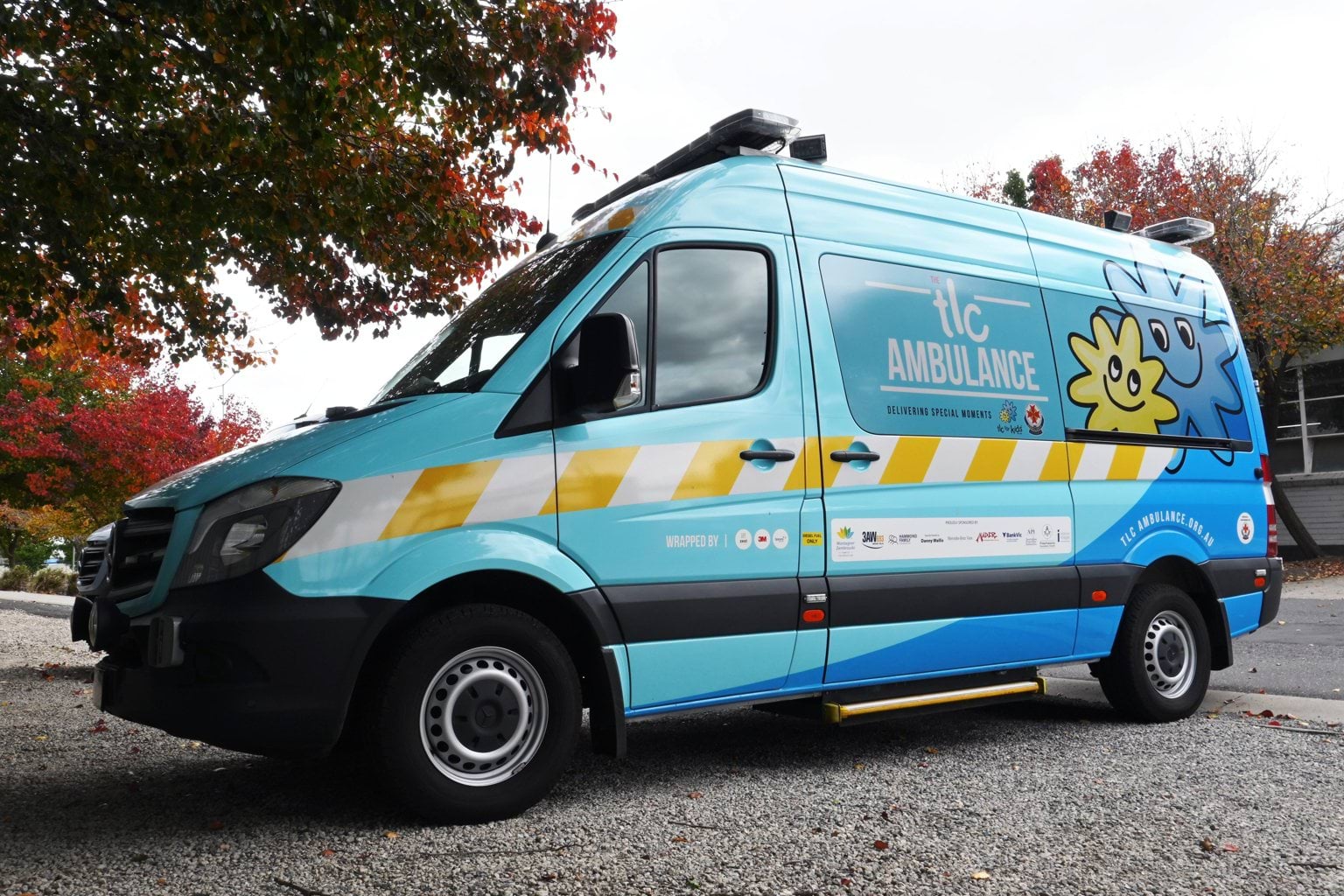 A blue ambulance vehicle which says TLC Ambulance on the side.