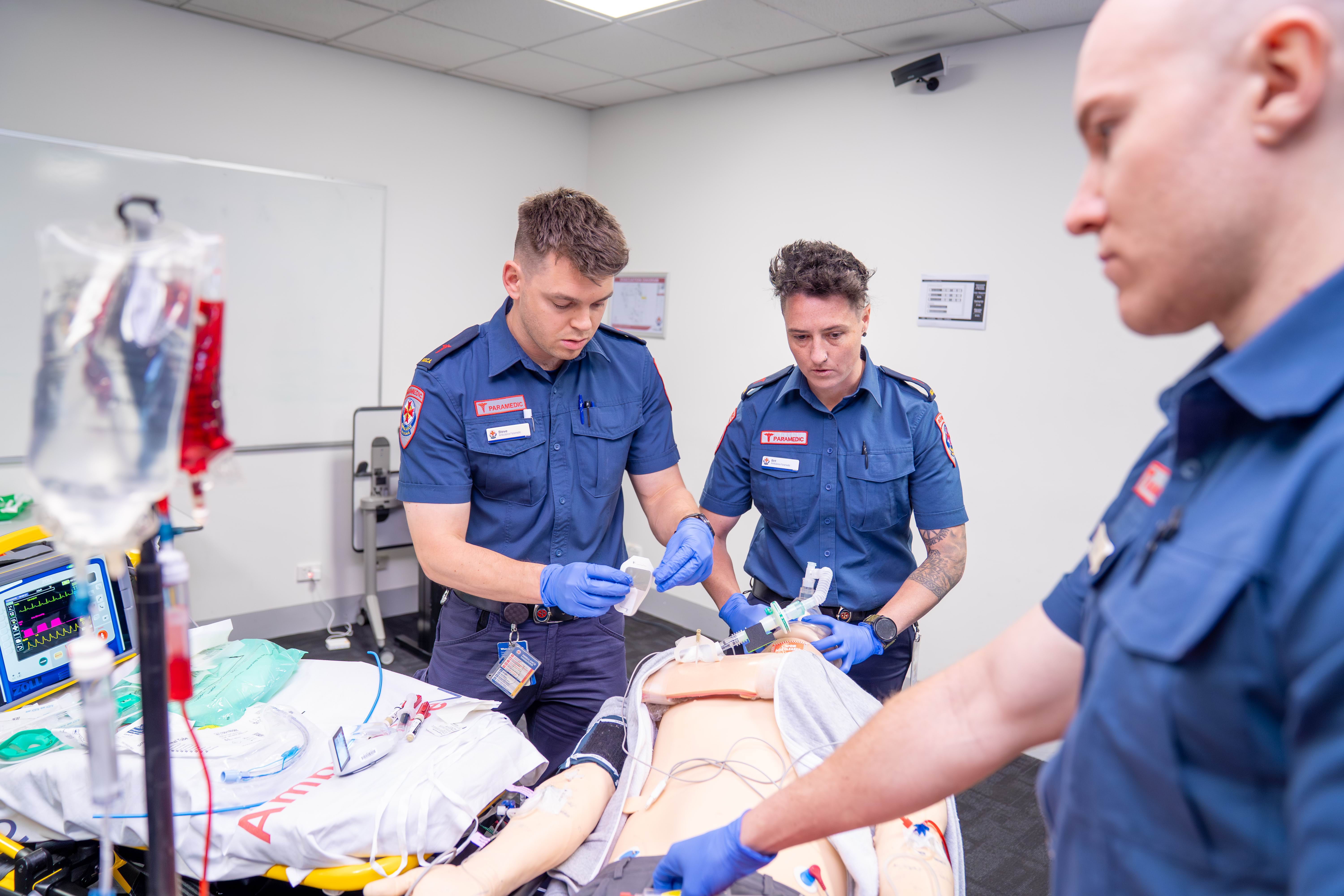 Three paramedics undertake a clinical training exercise.