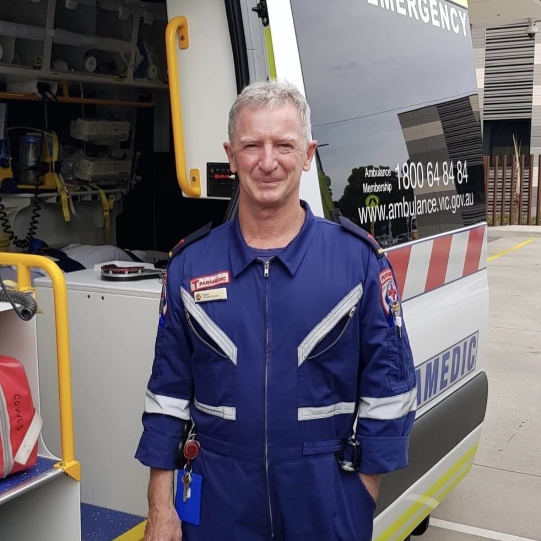 A man smiles for the camera in paramedic uniform.