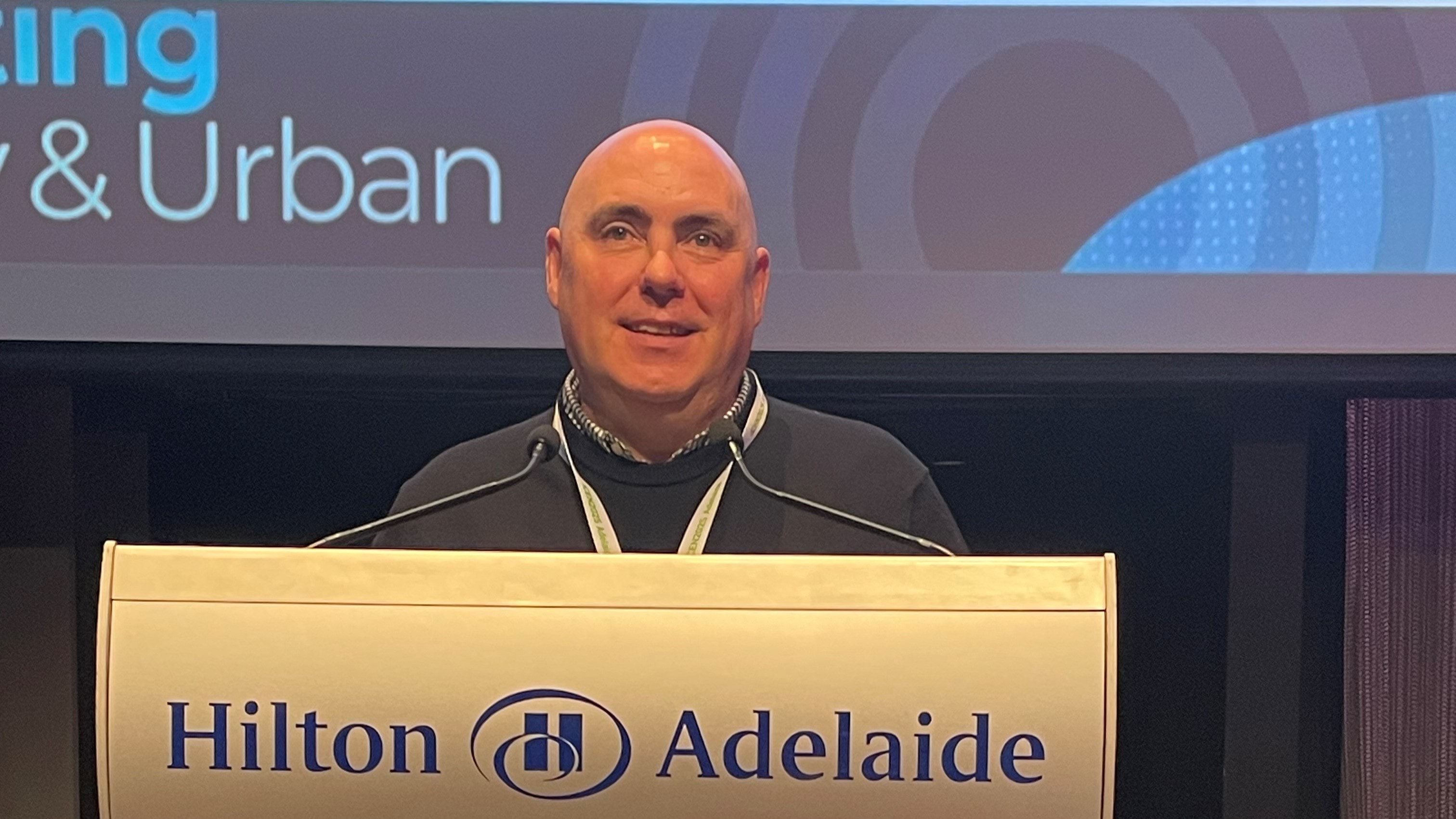 A man standing behind a lecturn. 