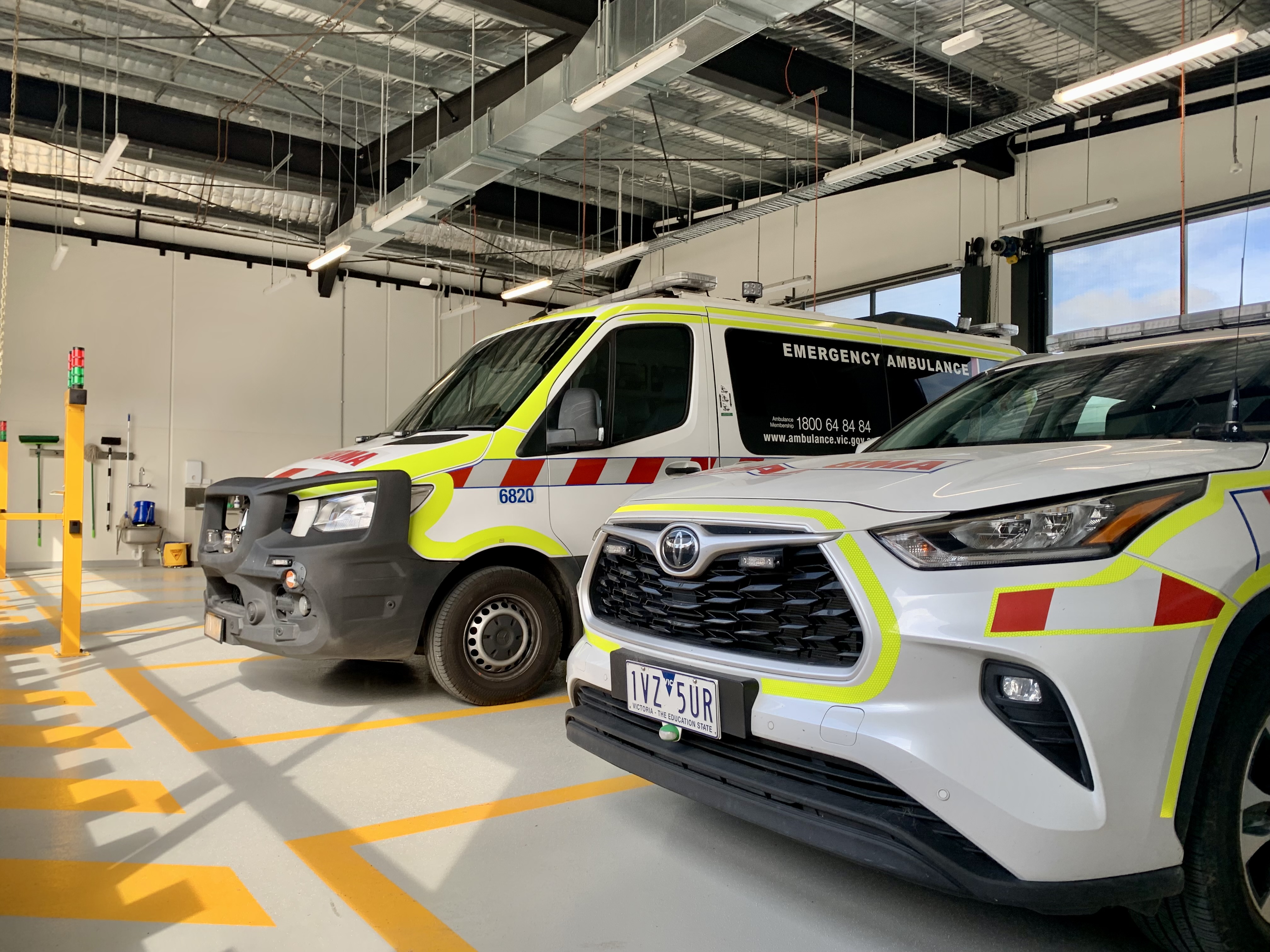 An ambulance branch garage with two vehicles and two empty parking spaces.