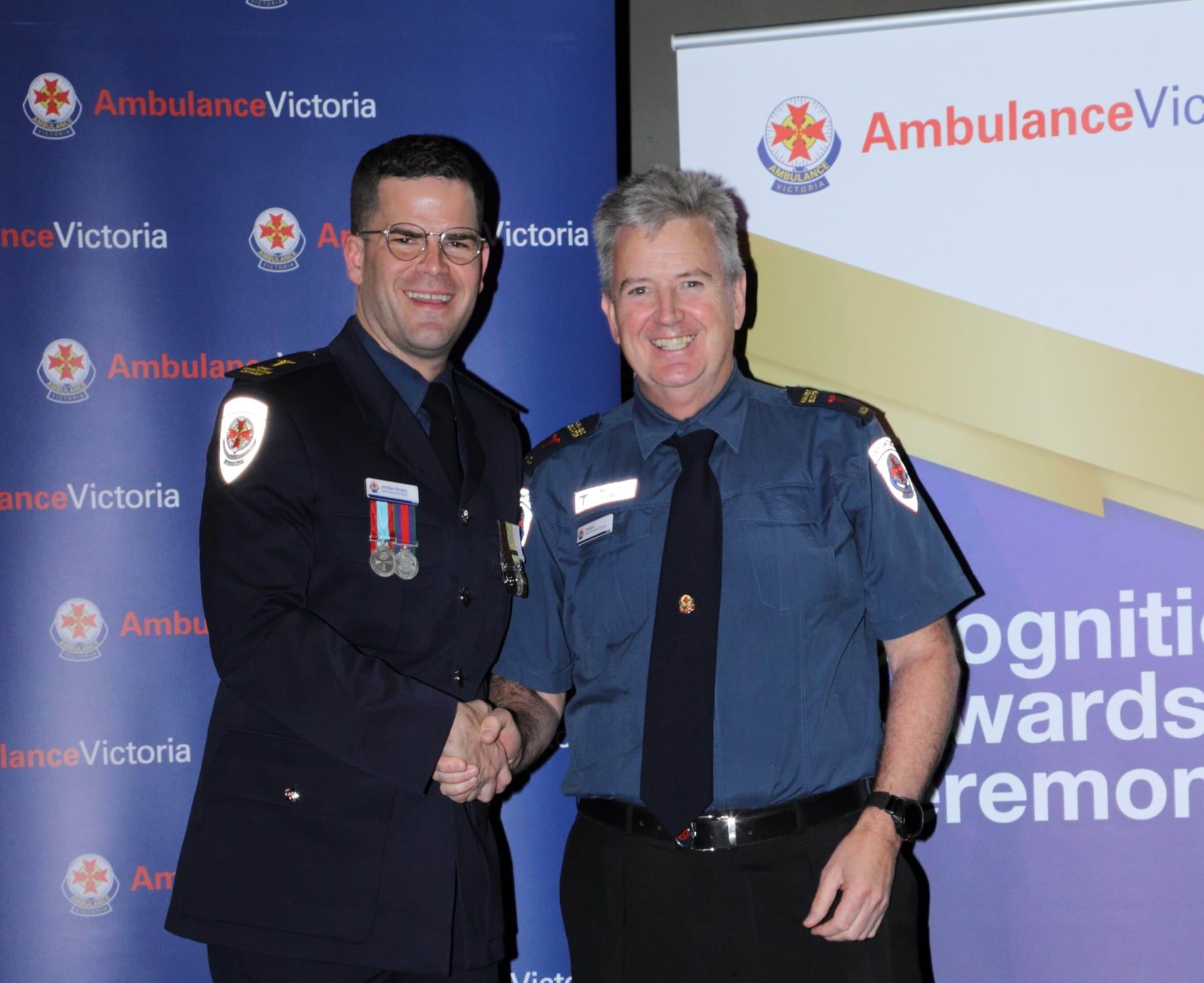 Two men in uniform shaking hands.