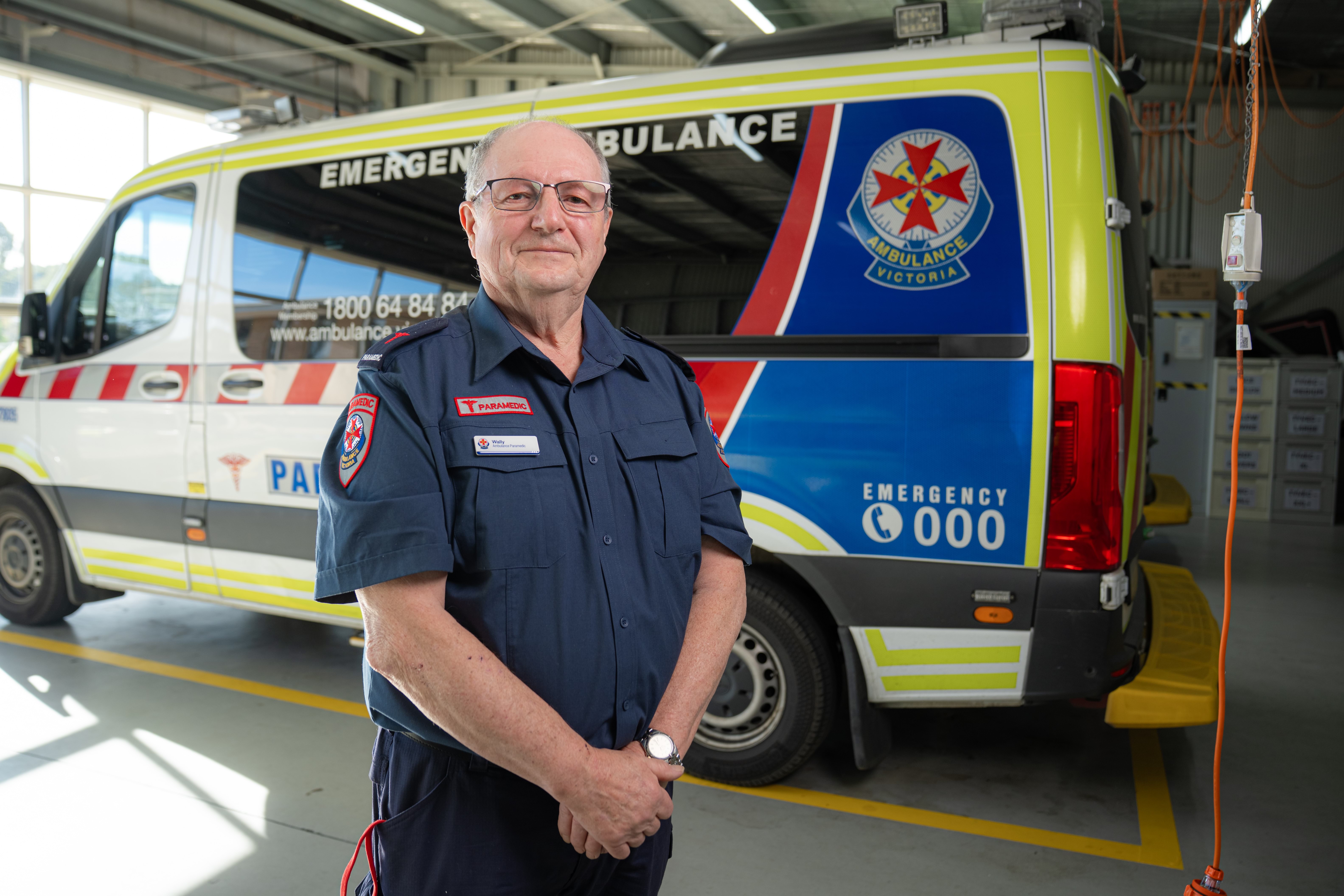 An Ambulance Victoria paramedic in front of an ambulance.