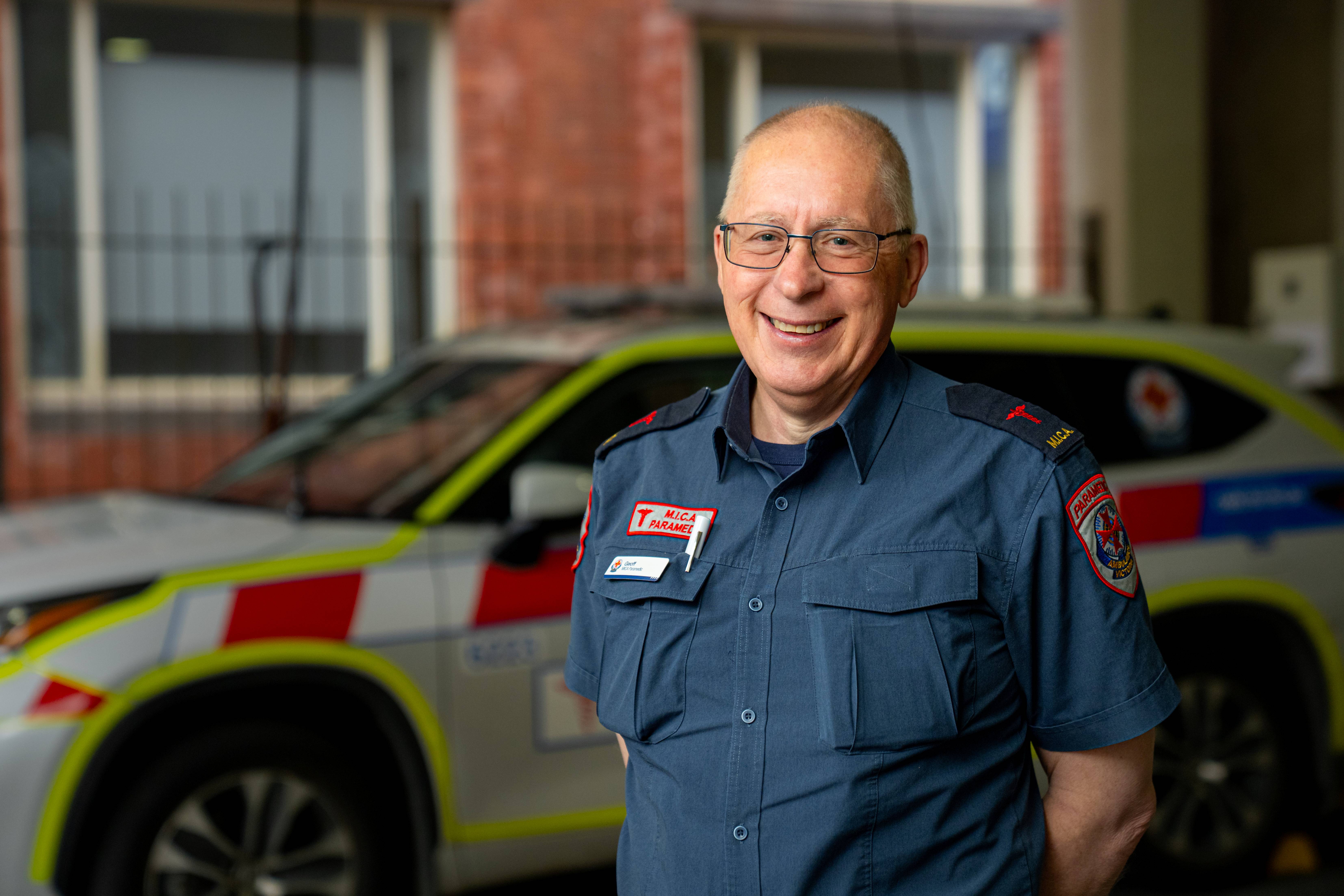 A MICA paramedic smiling in front of a MICA vehicle.
