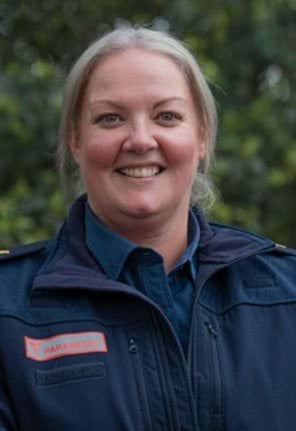 A woman in paramedic uniform smiles for the camera