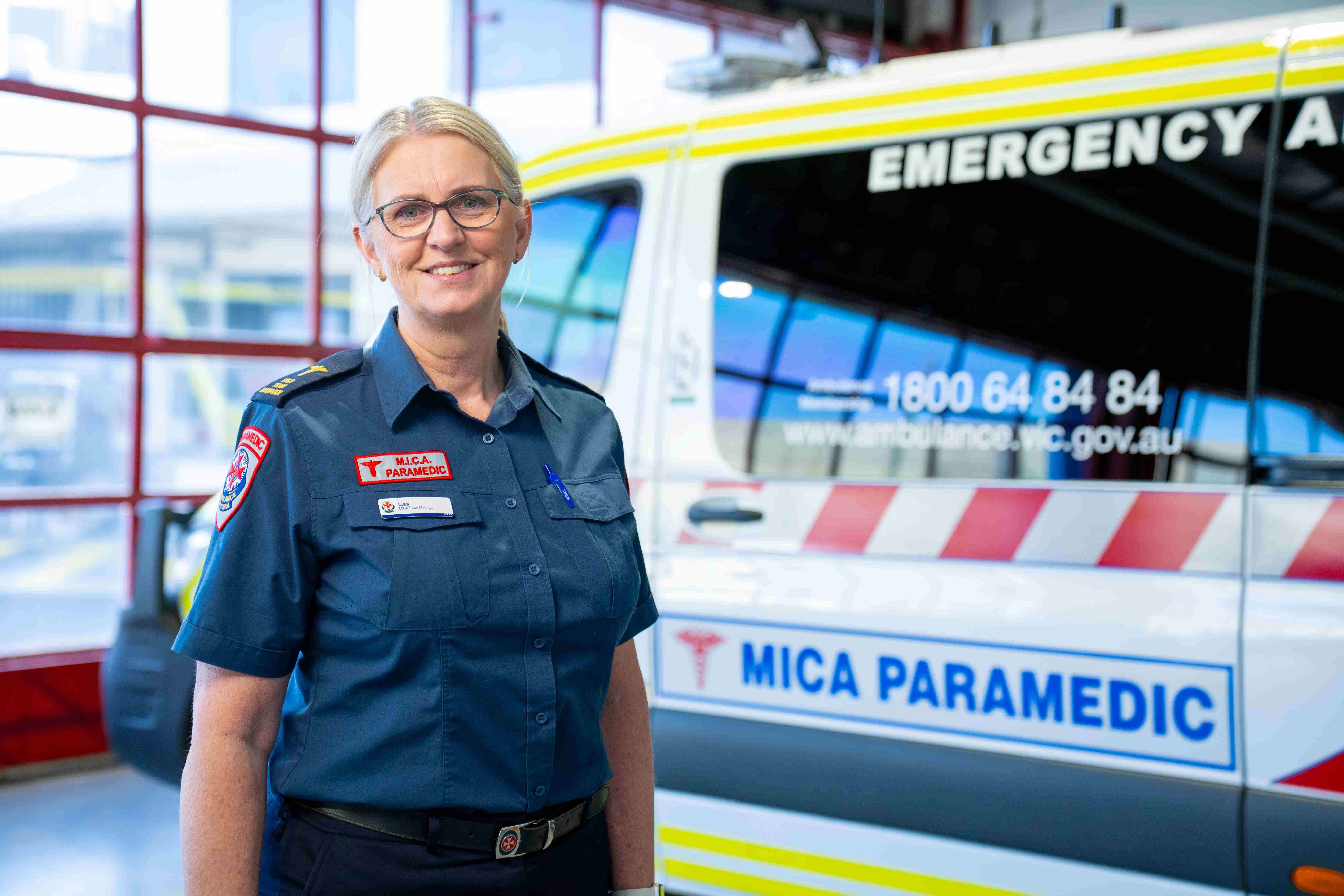 A woman standing in front of a MICA ambulance.