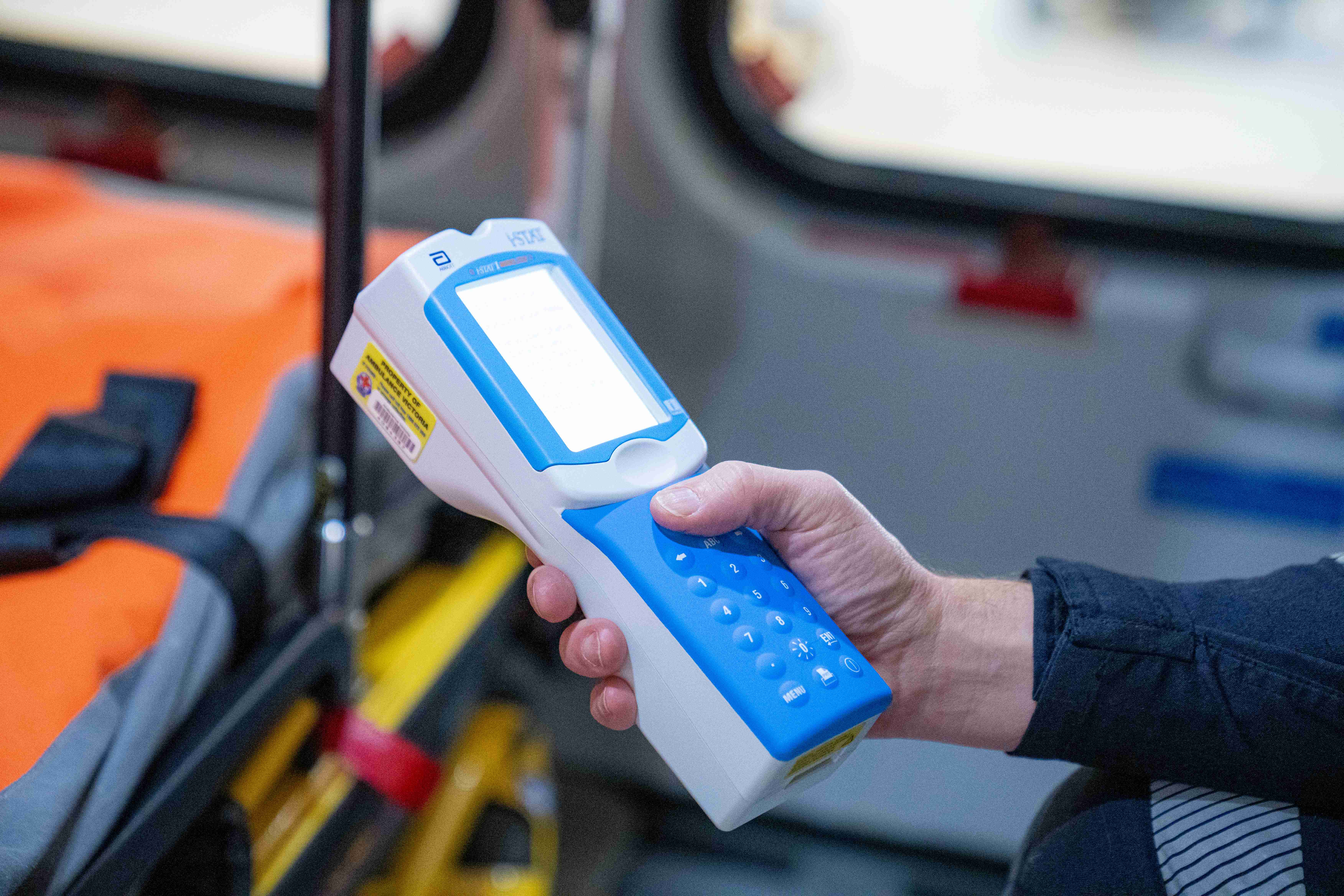 Someone holds a medical device in their hand.