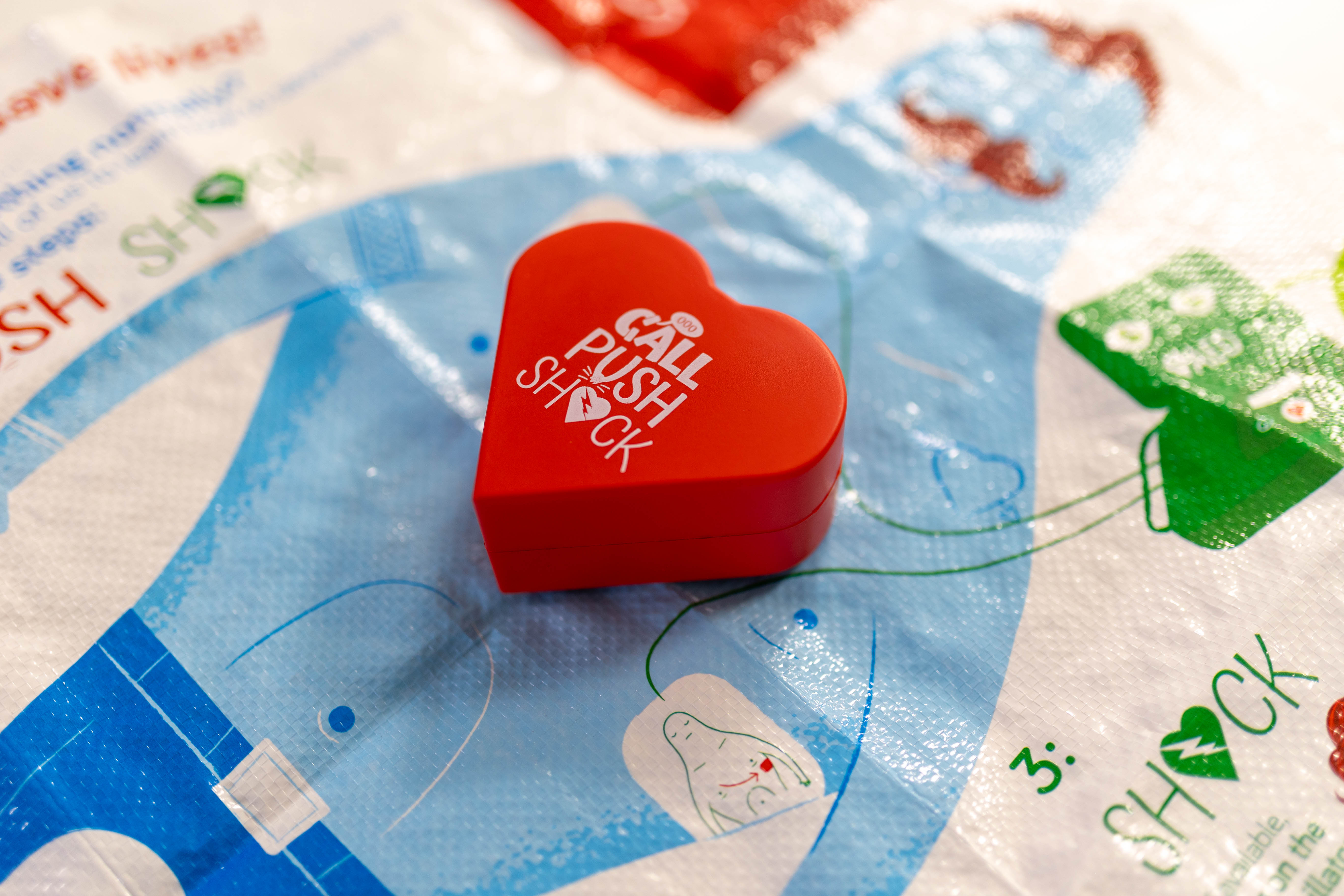 A red stress ball in the shape of a heart placed on top of an infographic sheet.