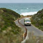 An ambulance drives along a coastal road