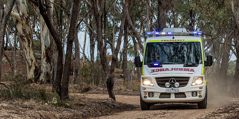 An ambulance driving through the bush in the Victorian outdoors