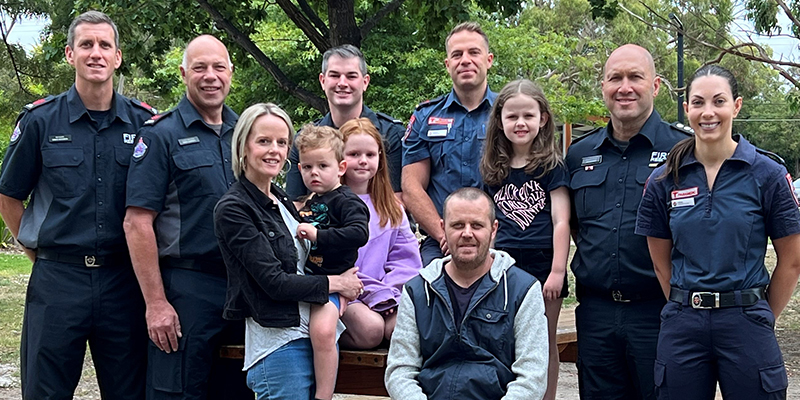 Duncan, Kim, and their children with the paramedics and firefighters who helped save Duncan's life