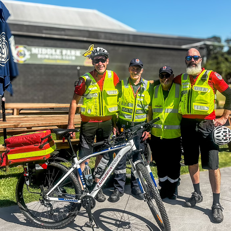 Four paramedics from the BRU looking at the camera with their bicycle.