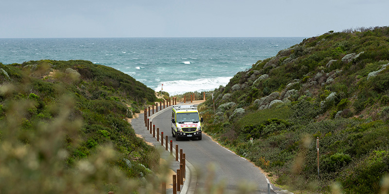 Ambulance driving along a coastal road and reminding Victorians to be cautious around water over the Labour Day long weekend.