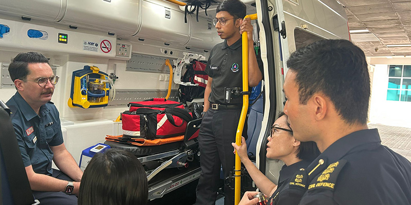Ambulance Victoria Medical Director Associate Professor David Anderson speaking to a number of Singapore Civil Defence Force personnel from inside an ambulance during his visit to Singapore in 2023.