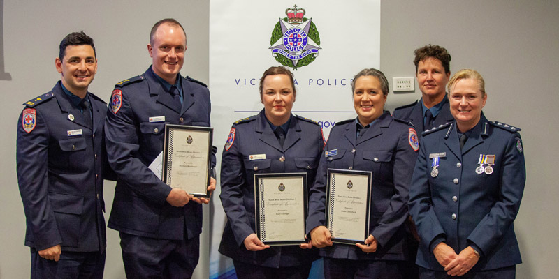 Three Ambulance Victoria staff stand with certificates