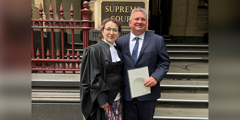 Ambulance Victoria Special Counsel Diana Valentine and Paul Jennings standing together outside the Supreme Court of Victoria. Paul is holding a certificate.